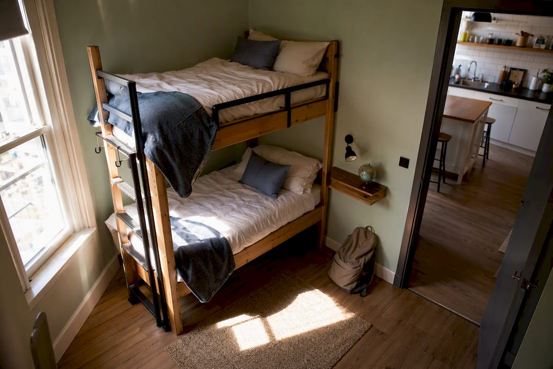 Hostel private room with bunk beds and kitchen entrance