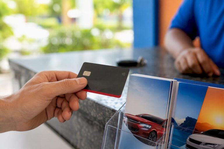 Hand holding credit card at rental counter