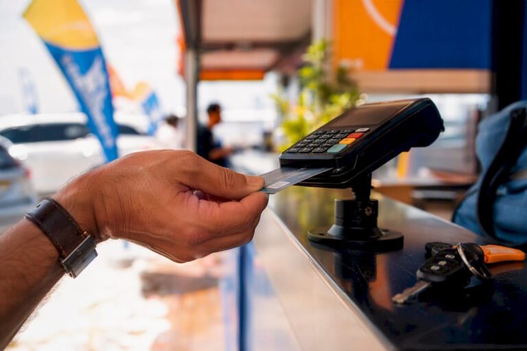 Hand inserting debit card at rental counter